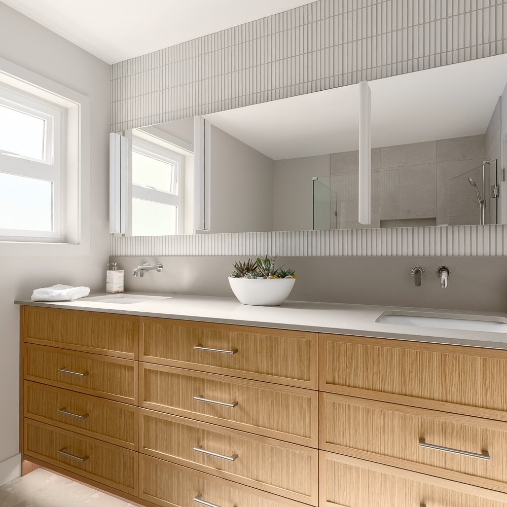 Double vanity bathroom with wood drawers and tile detailing